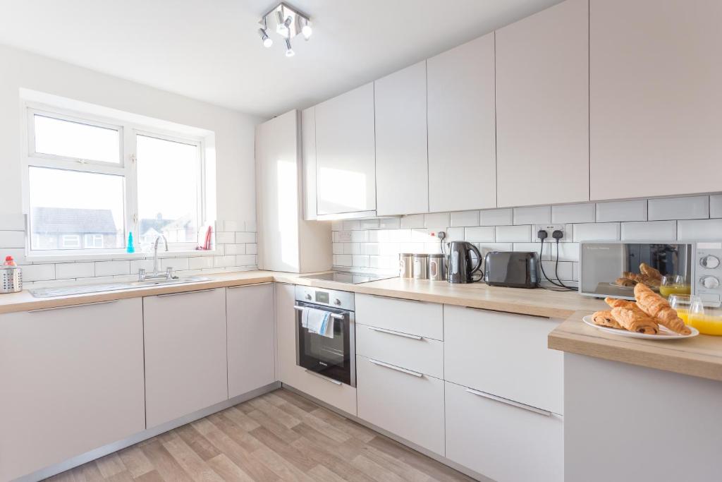 a white kitchen with white cabinets and a sink at Wren Suite Apt 2 Bed 1st Floor Apt close to Oxford Business & Science Parks in Oxford