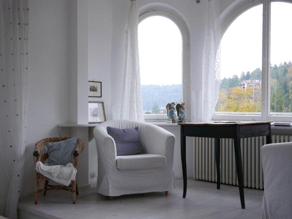 sala de estar con silla, mesa y ventana en Villa Himmelsblau, en Bad Herrenalb