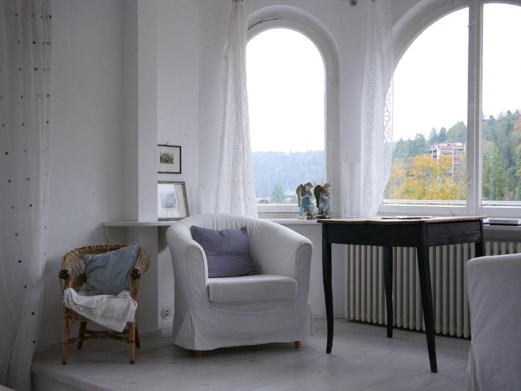 a living room with a chair and a table and a window at Villa Himmelsblau in Bad Herrenalb