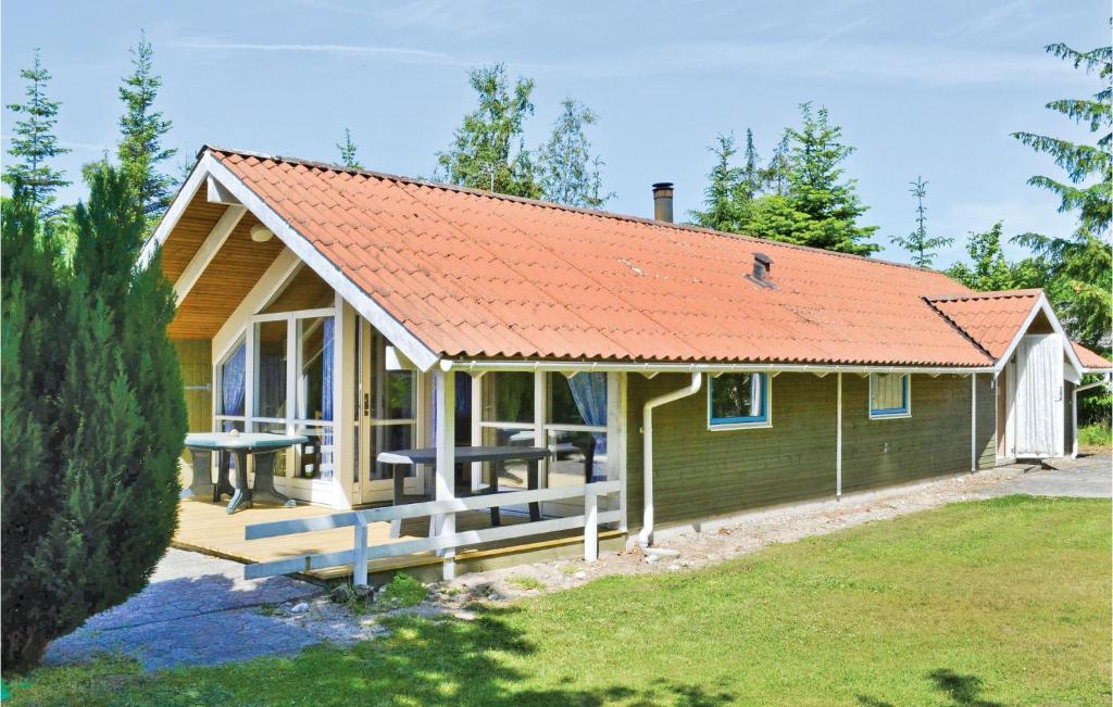 a small green house with an orange roof at Awesome Home In Ebeltoft With 4 Bedrooms, Sauna And Wifi in Ebeltoft