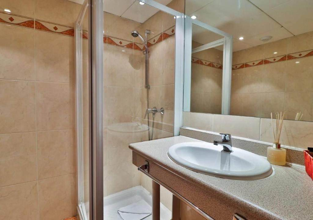 a bathroom with a sink and a shower at Hôtel restaurant Oasis in Nice