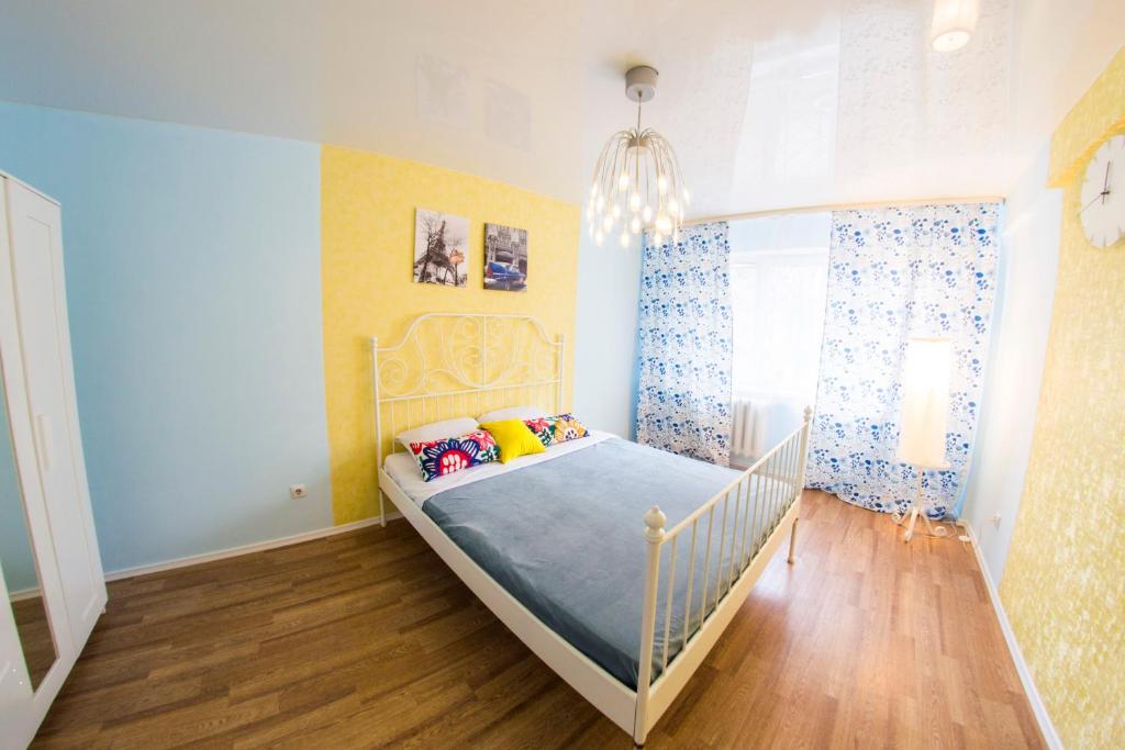 オムスクにあるRENT-сервис Апартаменты на Котовского, 16のベッドとシャンデリア付きの小さなベッドルーム1室