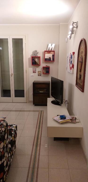 Televízia a/alebo spoločenská miestnosť v ubytovaní PIANO TERRA CON GIARDINO VICINO AL MARE