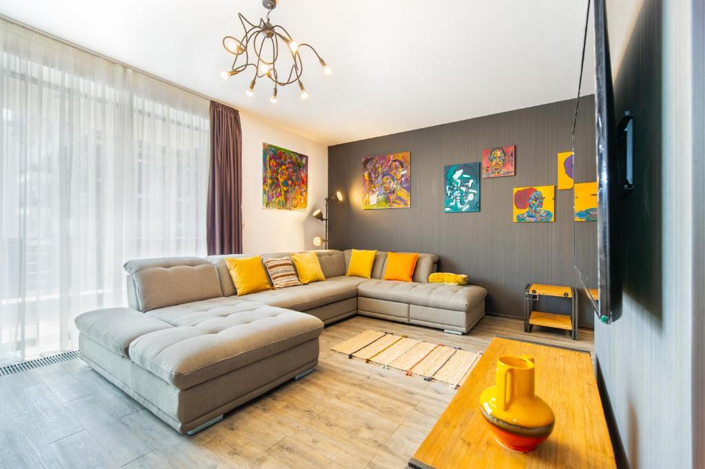 a living room with a couch and a tv at Art Gallery Apartment in Silver Mountain in Poiana Brasov