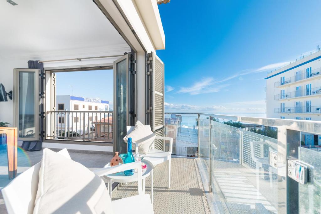 a balcony with a chair and a view of the city at Castello Platja in Santa Margalida