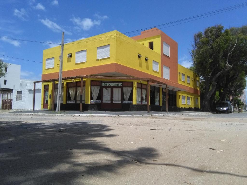 un edificio giallo all'angolo di una strada di Hotel Gli Amici a Mar de Ajó