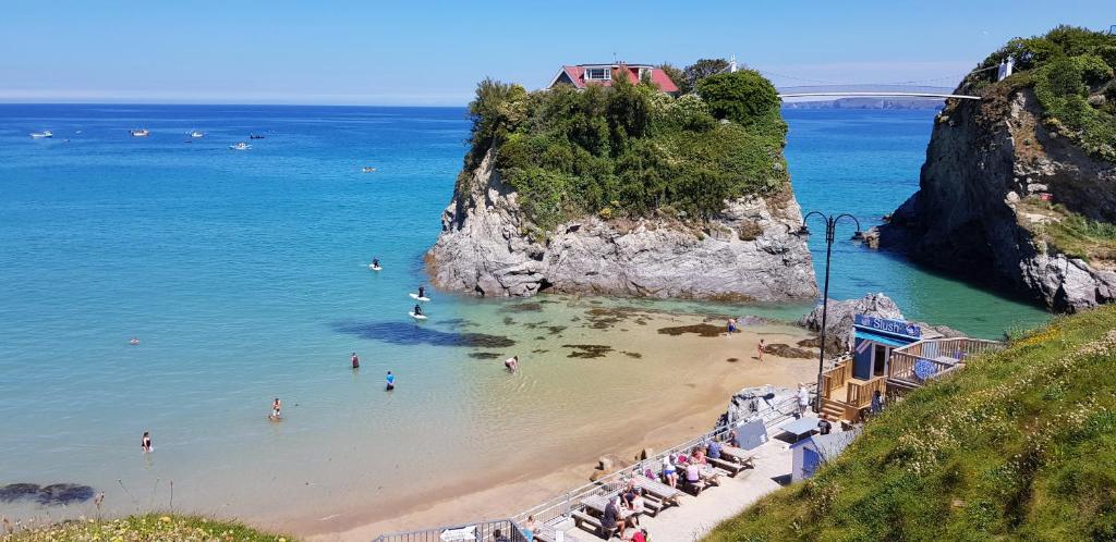 Une plage avec un tas de gens dans l'eau dans l'établissement OYO Minerva Guesthouse, à Newquay