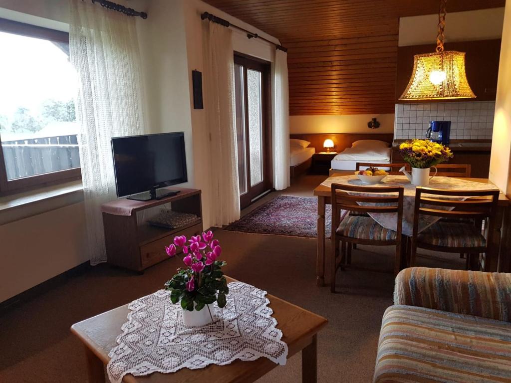 a living room with a couch and a table with flowers at Haus Talblick in Stocksberg