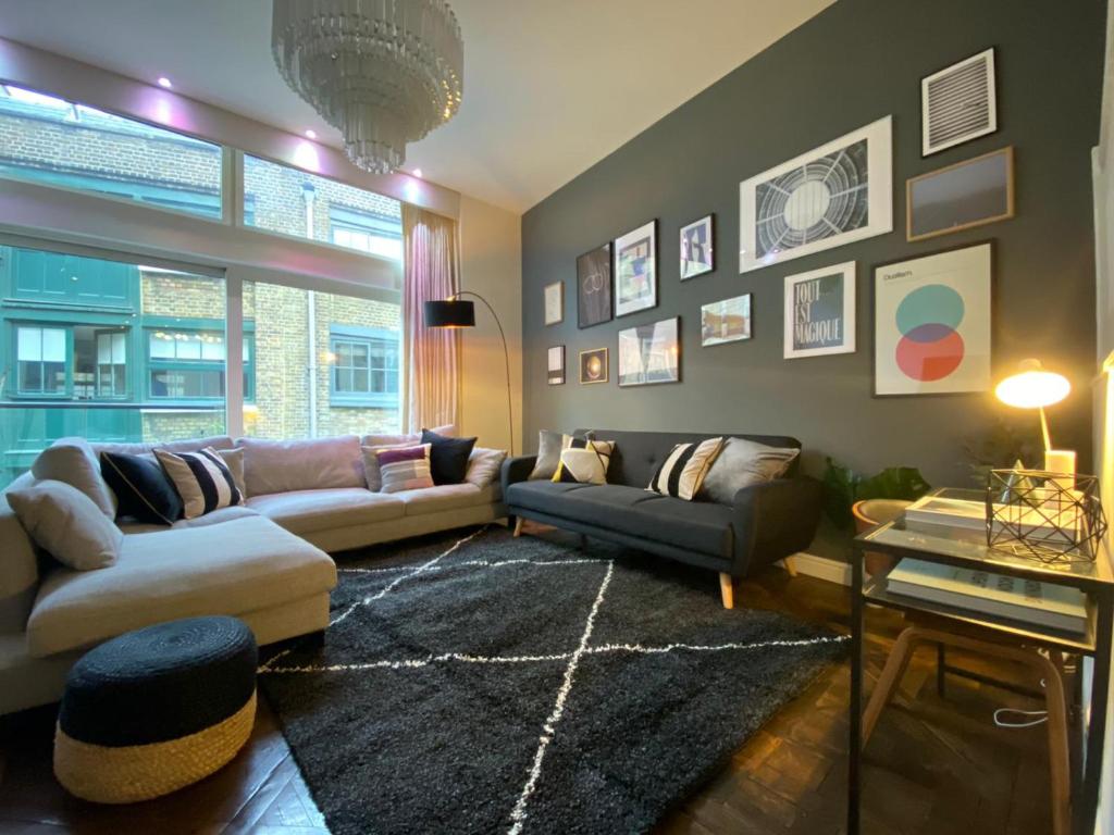 a living room with two couches and a rug at Foley Street Apartments in London