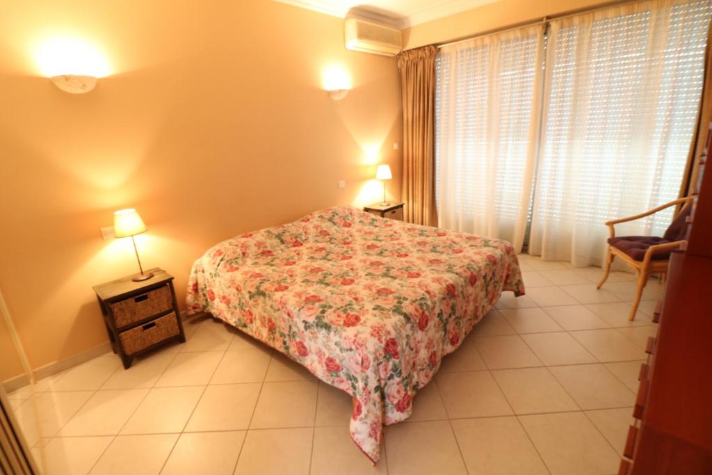 a bedroom with a bed and two lamps and a chair at 2, 3 and 4 bedroom sea view Forville Apartments 5 mins from the Palais in Cannes