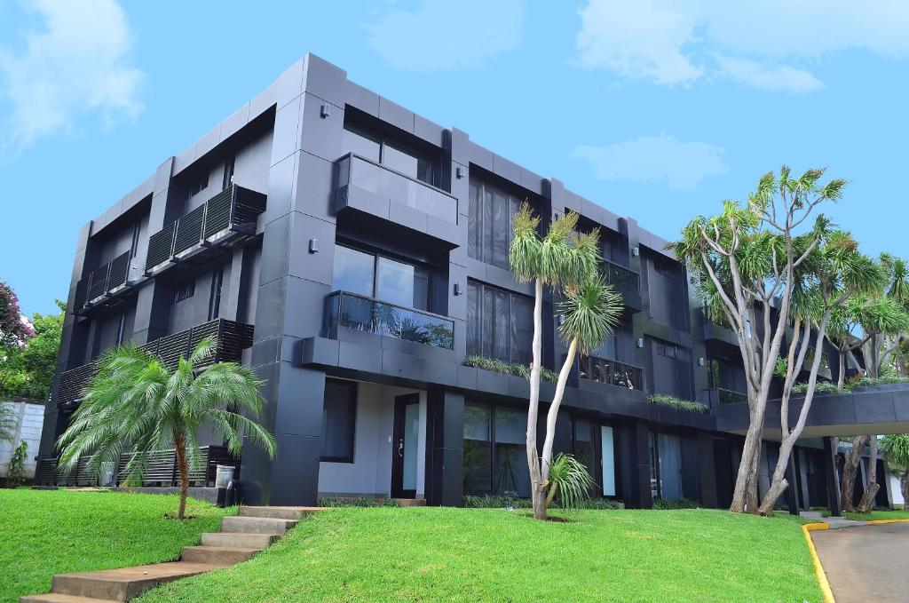 a building with palm trees in front of it at 中国人之家公寓酒店Apart-Hotel Casa de China in Managua