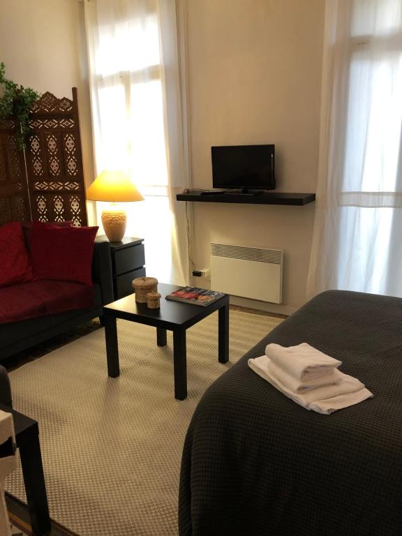 モンペリエにあるLes arceaux de Montpellierのベッド、ソファ、テーブルが備わる客室です。