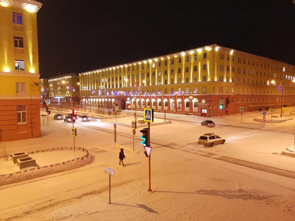 a city street at night with a building with lights at Центр г Норильска Ленинский 24 in Noril'sk