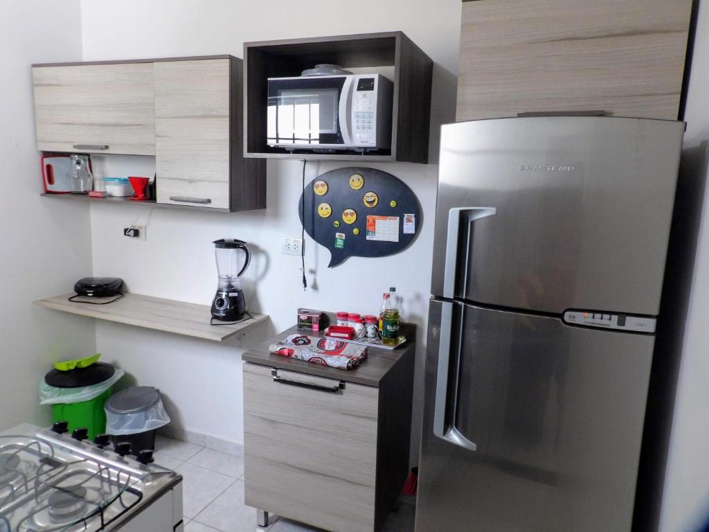a kitchen with a stainless steel refrigerator and a microwave at Flat Pé de Mamão in Campinas