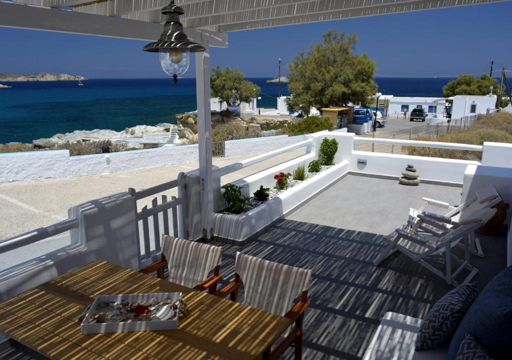 un patio con mesa, sillas y el océano en Seashell Mandrakia Sea view, en Mandrakia