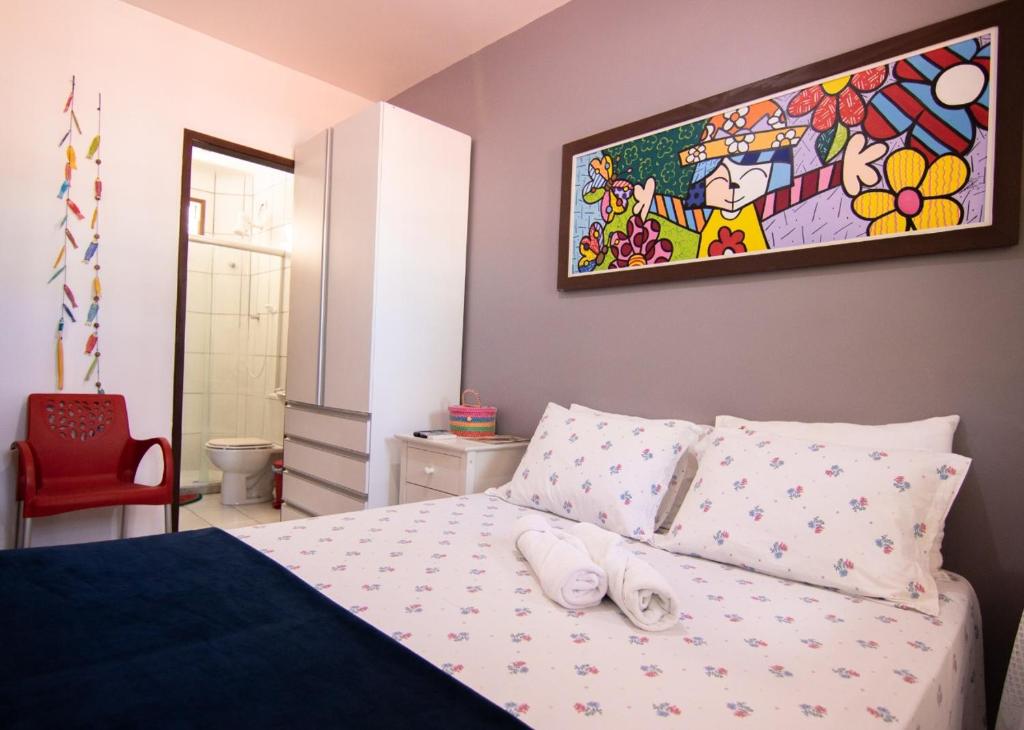 a bedroom with a bed with two white towels on it at Flat Bantu - Aconchegante Flat no coração de Porto de Galinhas - Aqui seu pet é bem vindo in Porto De Galinhas
