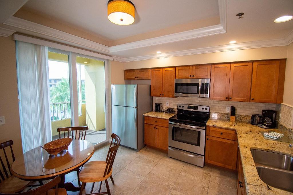 a kitchen with wooden cabinets and a table with a tableablish at Vanderbilt Beach Resort in Naples