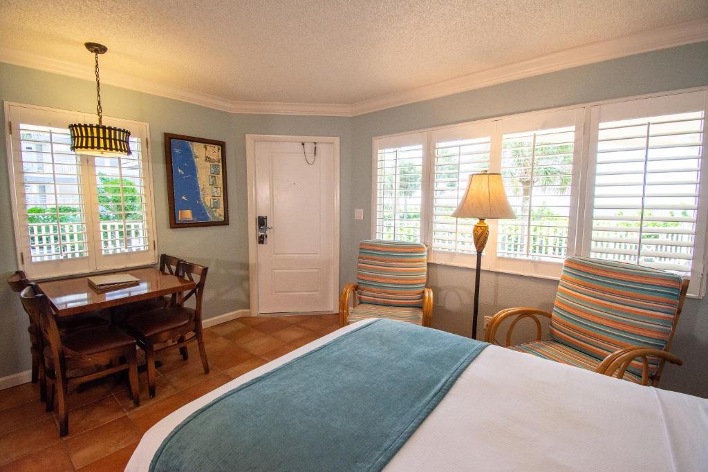 a bedroom with a bed and a desk and chairs at Vanderbilt Beach Resort in Naples