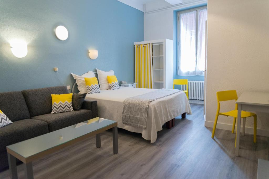 a hotel room with a bed and a couch at Hotel Toppin in Cavaillon