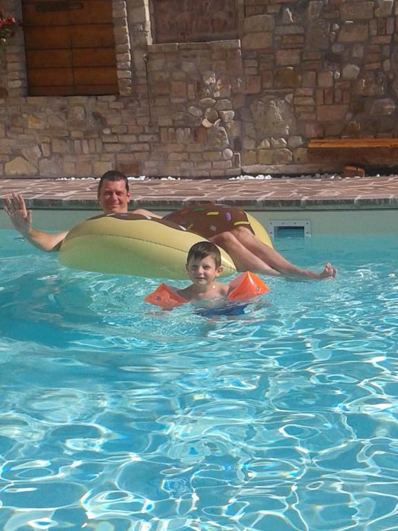 a man and a child in a swimming pool at Siore Marie gli alloggi in San Giórgio di Nogaro