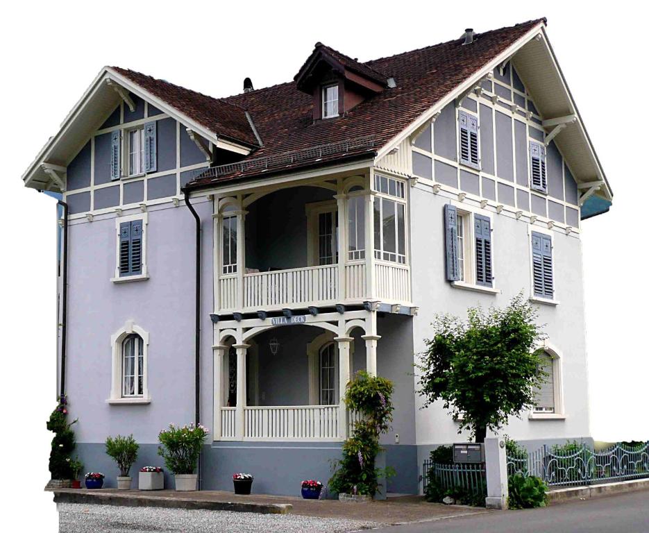 a large white house with a gambrel roof at Villa Deck in Brunnen