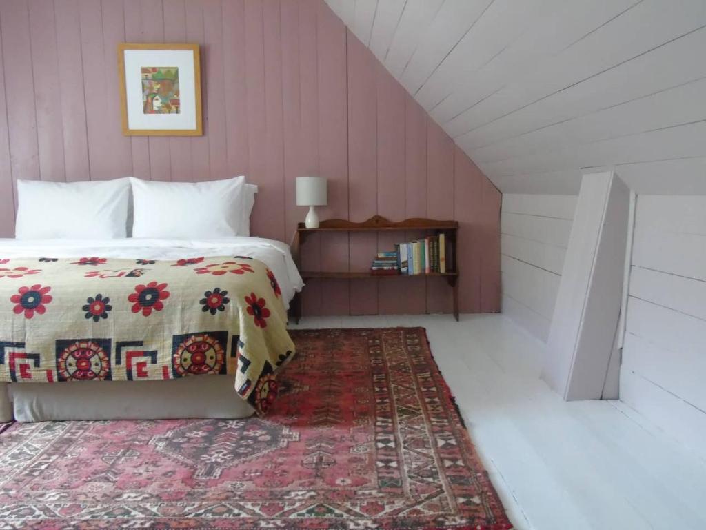 Schlafzimmer mit einem Bett und einem roten Teppich in der Unterkunft Stable Cottage, CrannachCottages in Garve