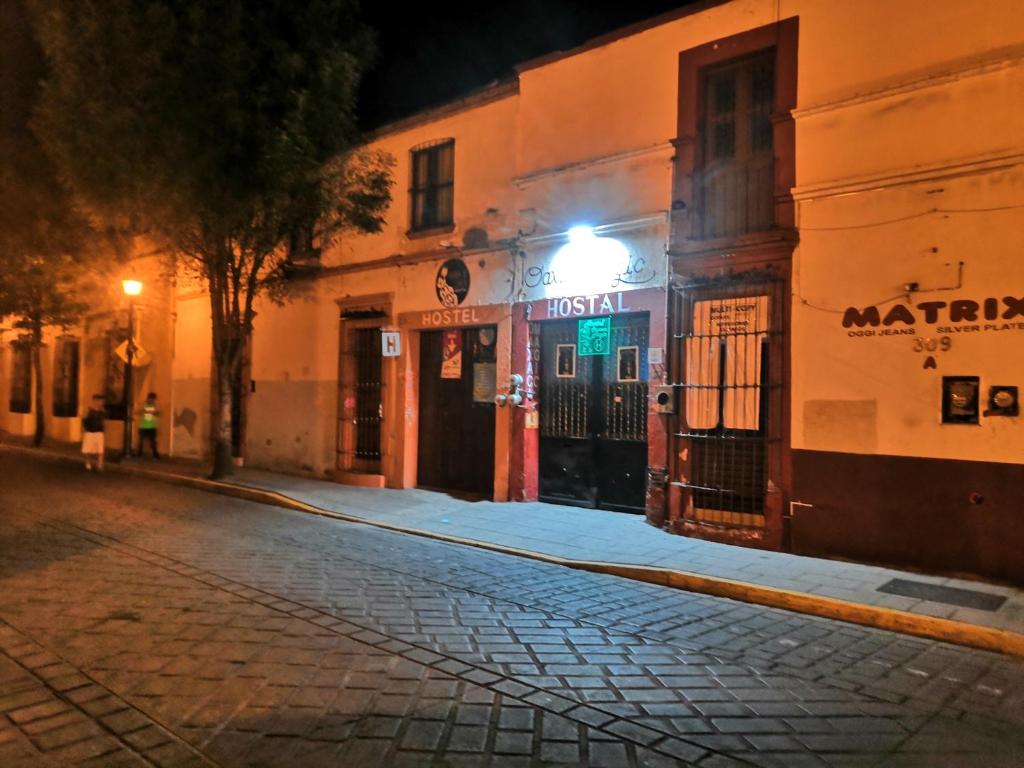 an empty street at night with a building at Hostal Oaxaca Magic in Oaxaca City