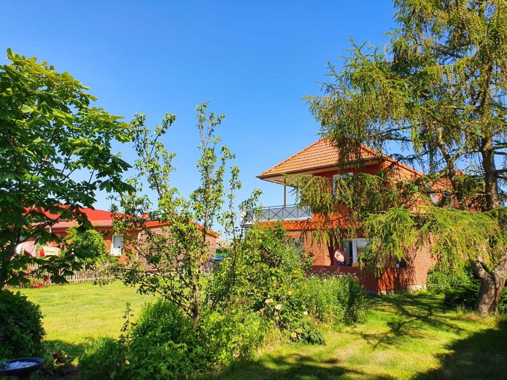 ein Haus inmitten eines Gartens mit Bäumen in der Unterkunft Ferienhof Stobbe in Grube