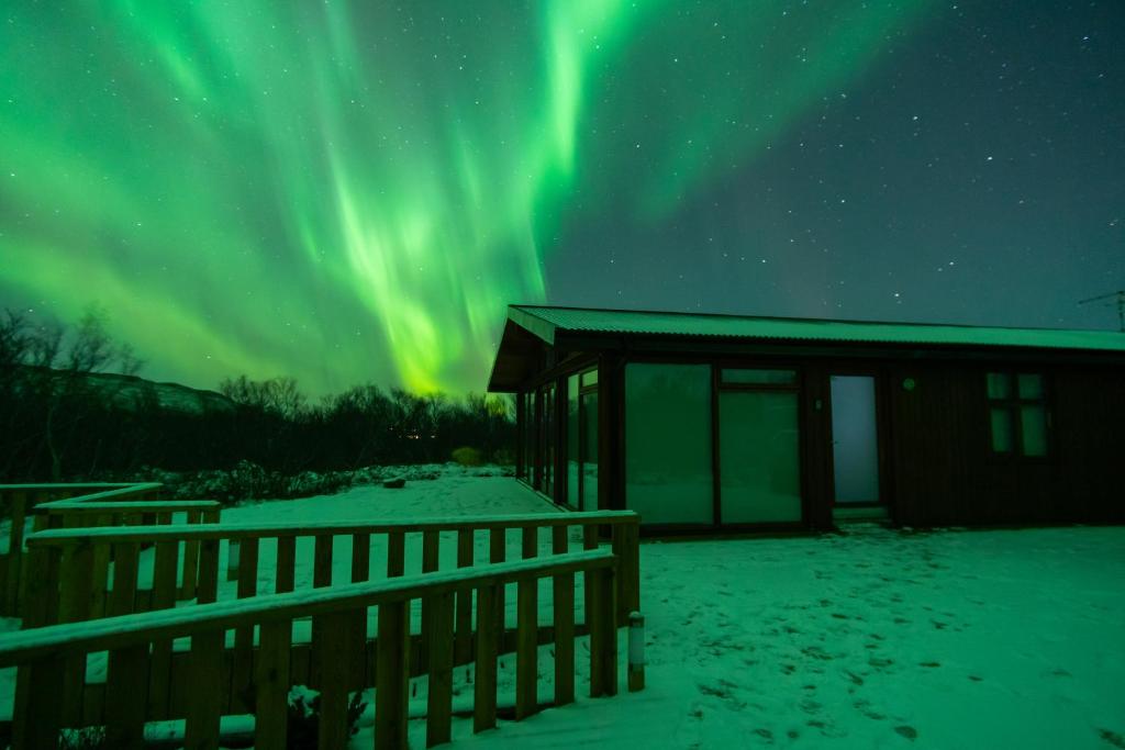 una cabaña con la aurora en el cielo en Harpa Holiday Home - Birta Rentals, en Húsafell