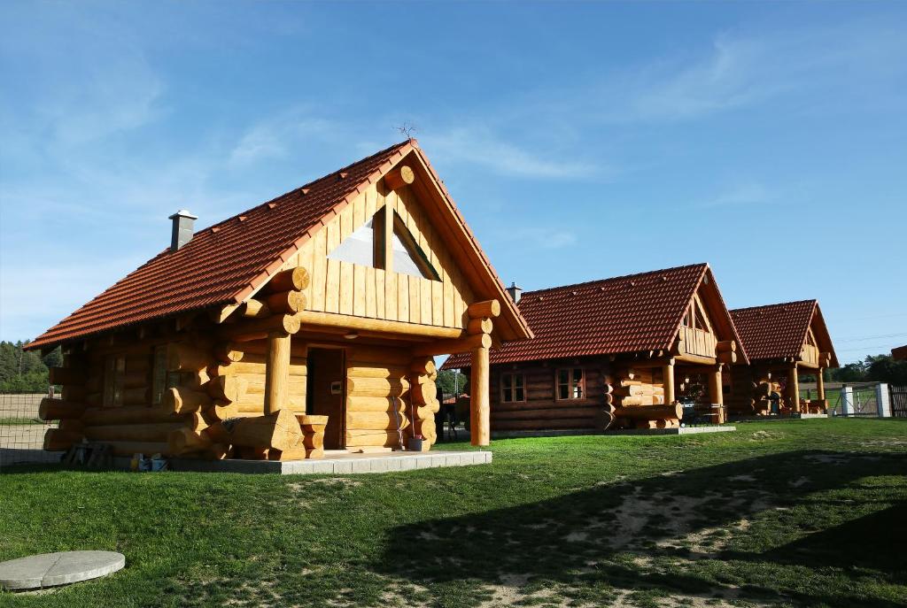 a log cabin with a roof on a green field at Na Samotě Ve Srubu in Plzeň
