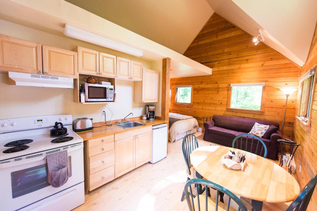 una cucina e una sala da pranzo con tavolo in una cabina di Across the Creek Cabins a Clearwater