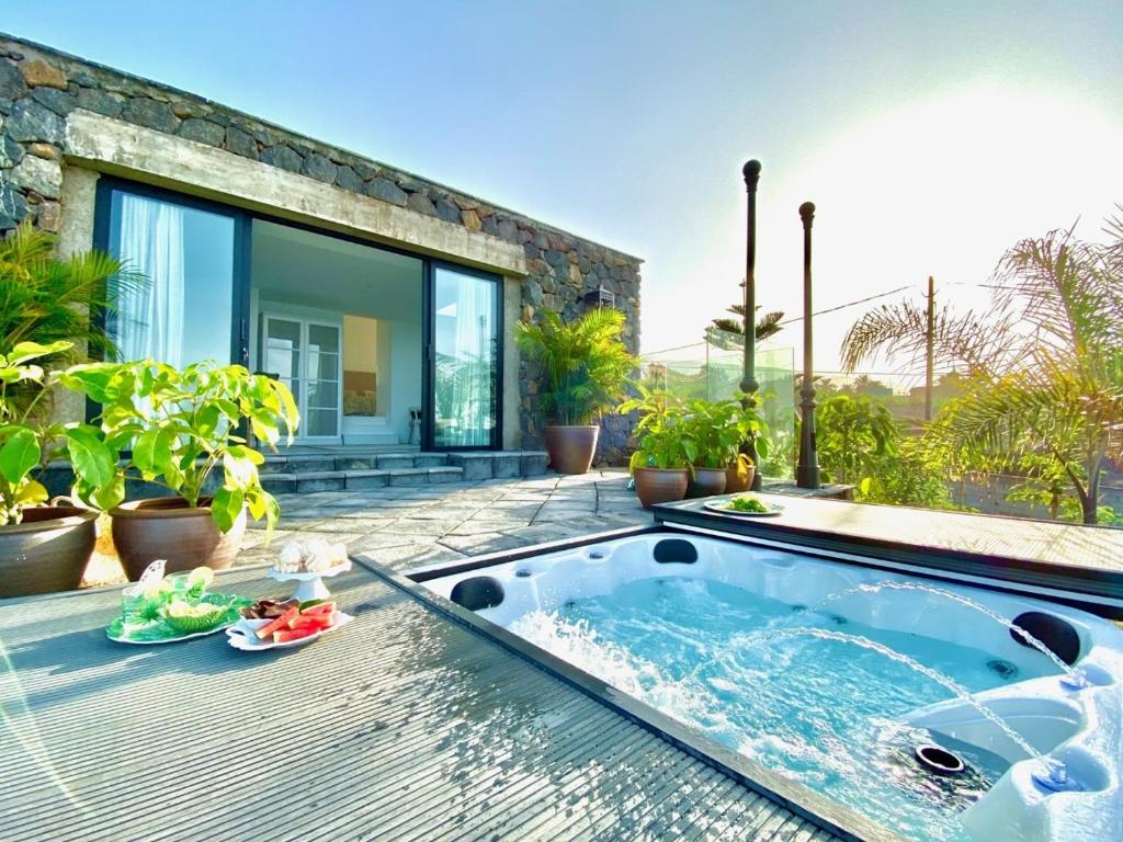 een hot tub op de patio van een huis bij Casa Lava Luminosa y con Magníficas Vistas in La Orotava