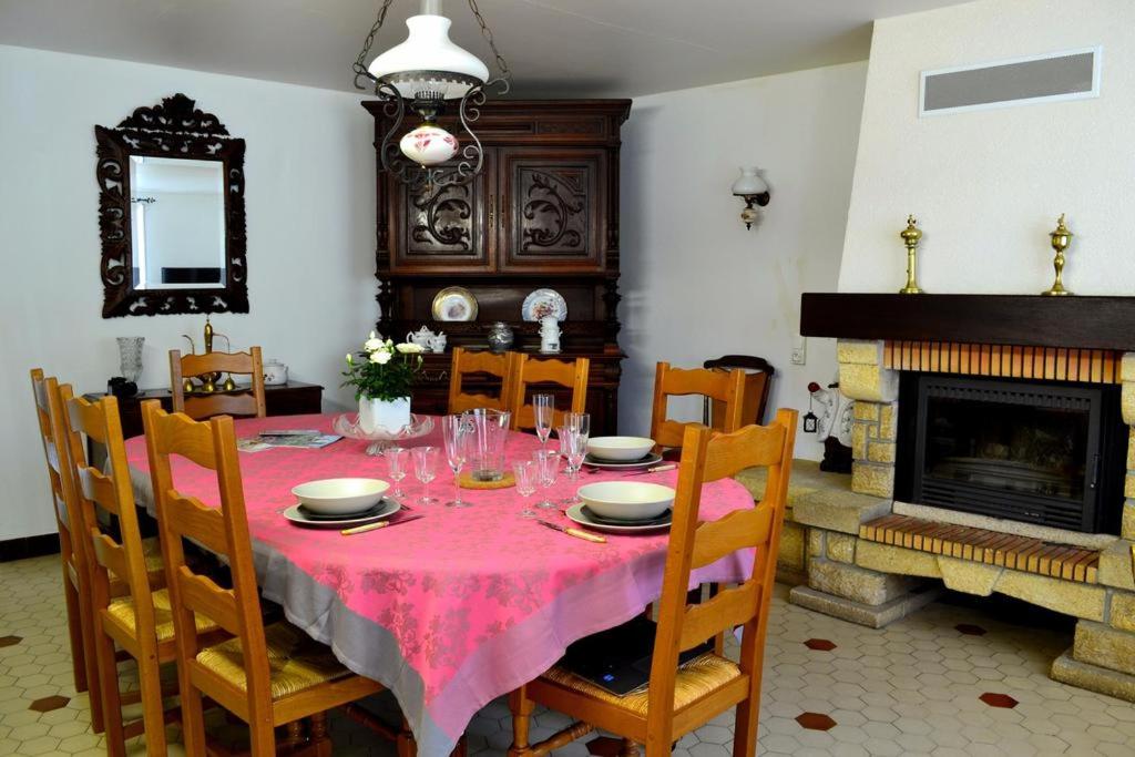 uma sala de jantar com uma mesa e uma lareira em Gite Le Masgiral em Saint-Christophe