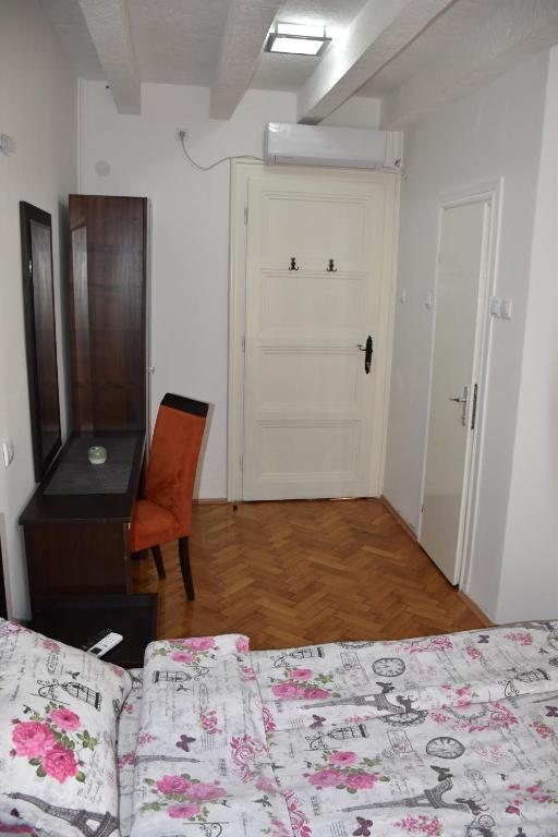 a bedroom with two beds and a desk and a door at Exit Labirint Centar in Novi Sad