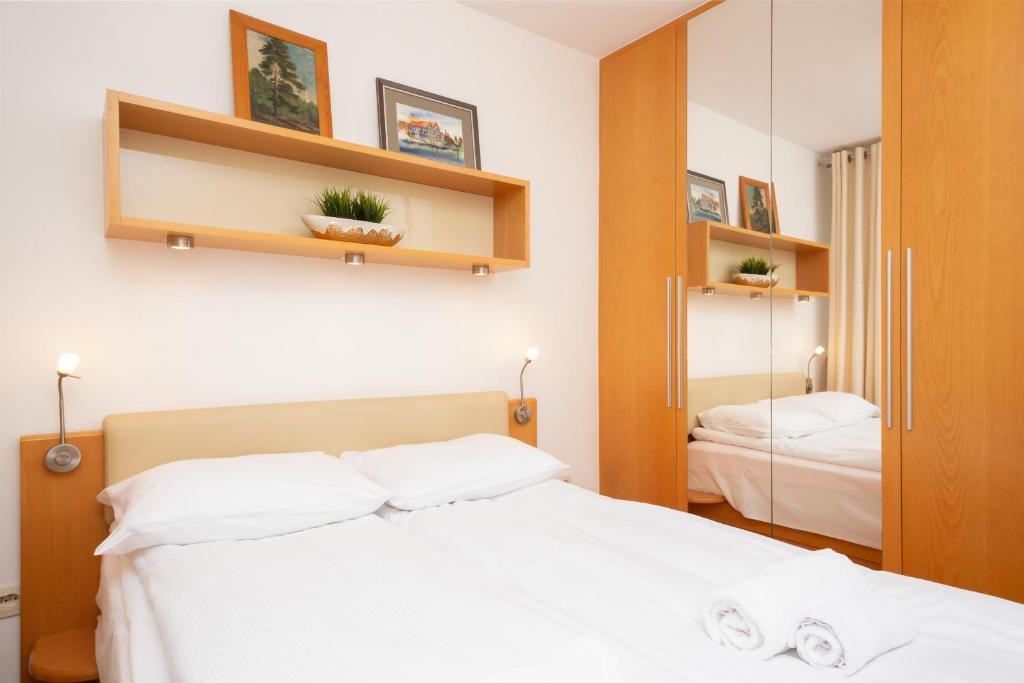 een slaapkamer met een wit bed en een spiegel bij Two-Bedroom Family Apartment Esperanto next to Klif by Renters in Warschau