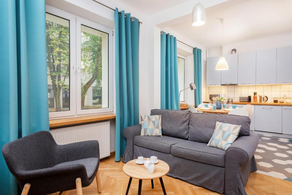 een woonkamer met een bank en een tafel bij Apartments Warsaw Franciszkańska in Warschau