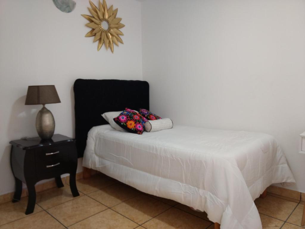 1 dormitorio con 1 cama y 1 mesa con lámpara en HABITACIÓN ALBORADA 1 con baño privado, en Lima