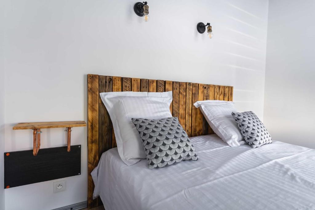 una camera da letto con letto, lenzuola e cuscini bianchi di La Dimiere - Le Postel - Appartements de standing en hyper-centre - Louviers a Louviers