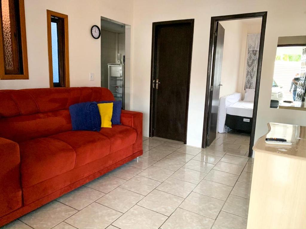 sala de estar con sofá rojo y cocina en Residencia ideal para ir ao Beto Carrero, en Penha