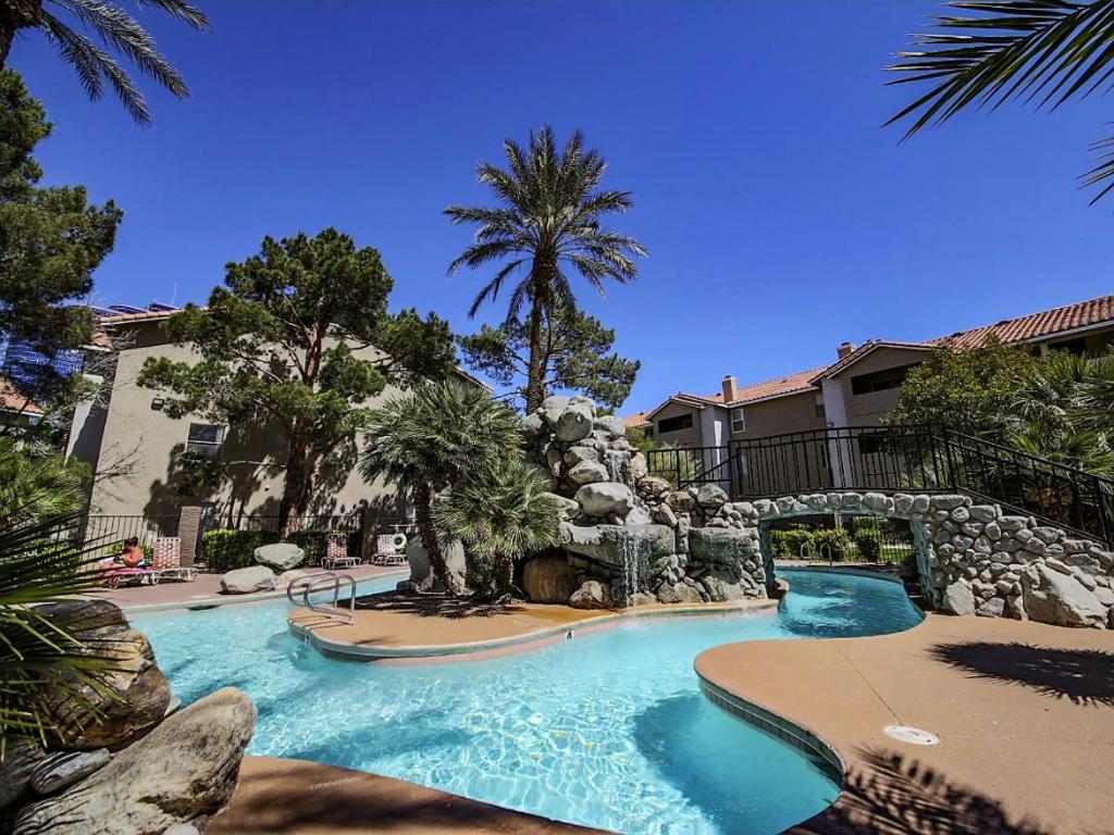 a swimming pool with a waterfall in a resort at Lovely condo! Walking distance to the Strip with pool and spa in Las Vegas