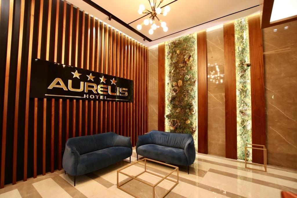 hol z 2 niebieskimi krzesłami i znakiem hotelowym w obiekcie Aurelis Hotel w mieście Bërxull