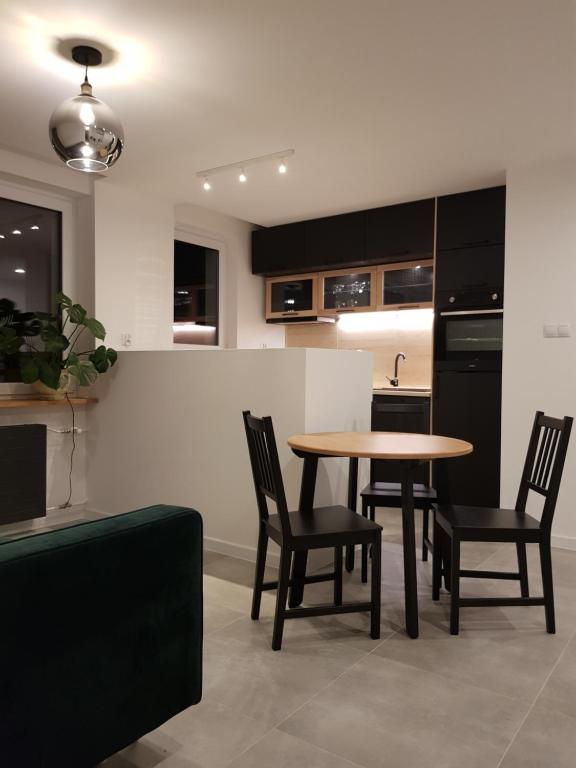 a kitchen with a table and chairs in a room at MISVEST Maria IV Arena Gliwice in Gliwice