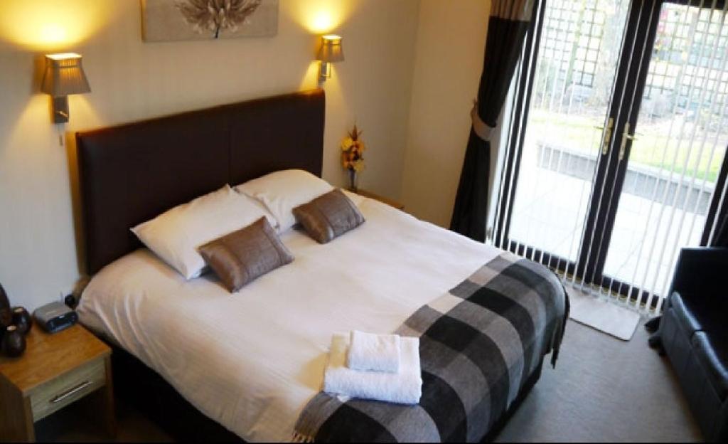 a bedroom with a large bed with two pillows on it at Ban-Car Hotel in Cairness