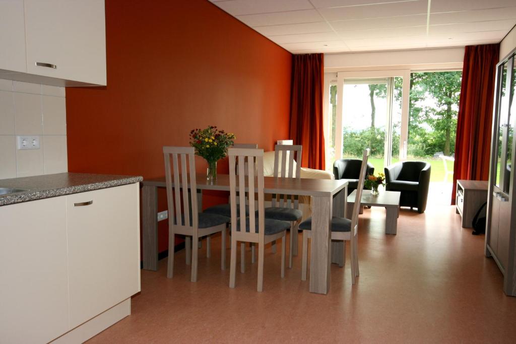 una cucina e una sala da pranzo con tavolo e sedie di Vakantie-Oord "De Hulsdonken" a Bergeijk