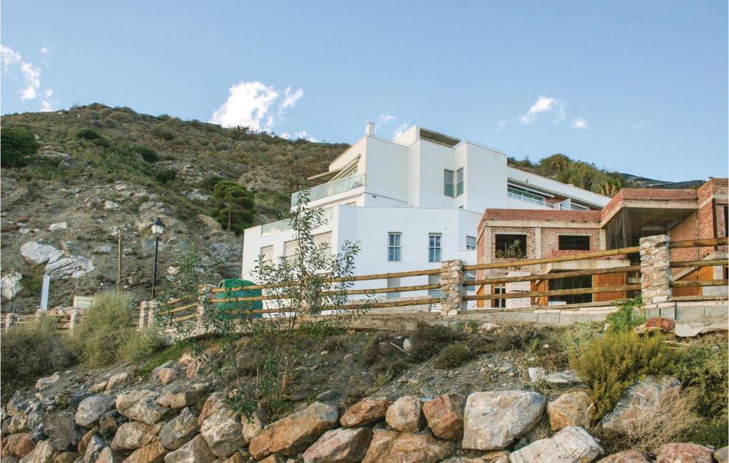 ein weißes Haus an der Seite eines Hügels in der Unterkunft Awesome Apartment In Casarones With Kitchen in Castillo de BaÃ±os