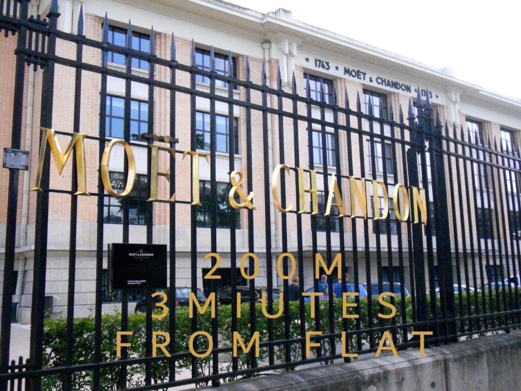 a sign on a fence in front of a building at Champagne Studio in Épernay