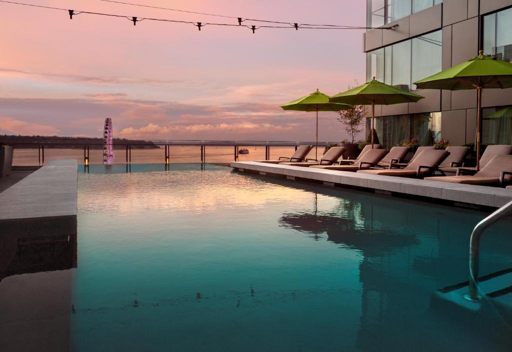 uma piscina com cadeiras e guarda-sóis ao lado de um edifício em Four Seasons Hotel Seattle em Seattle