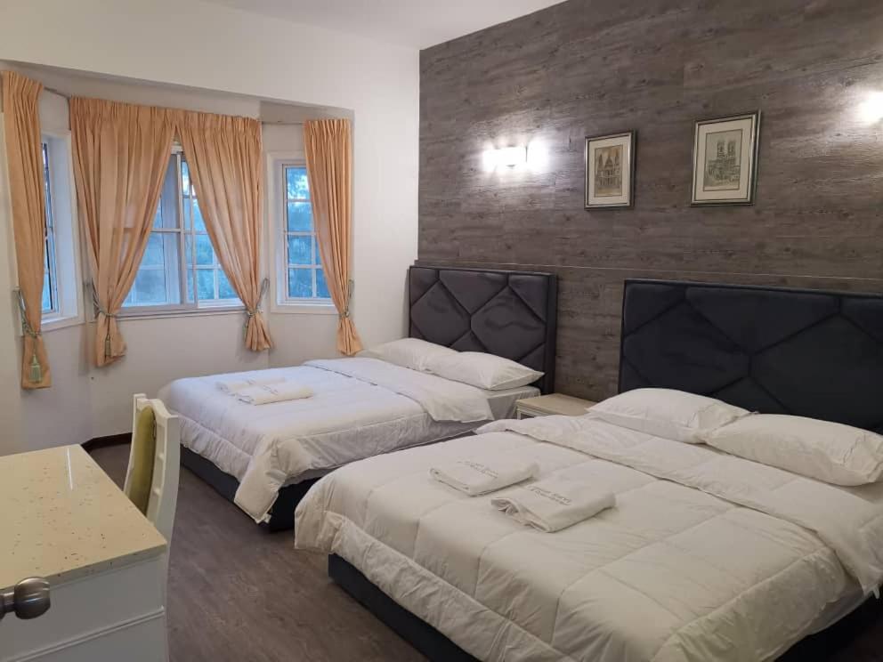 - une chambre avec 2 lits, une table et des fenêtres dans l'établissement Hills Sanctuary Retreat, B7-3A-2 with WI-FI, à Bukit Fraser