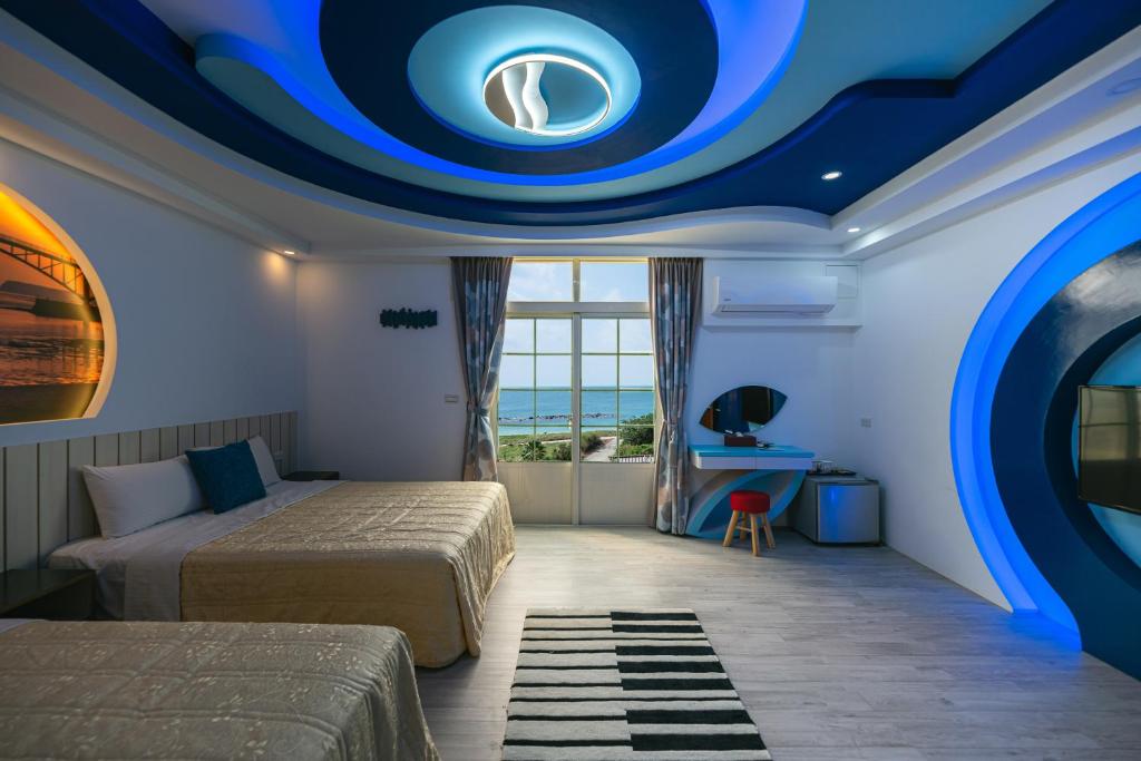 馬公市的住宿－藍海風晴，一间卧室设有两张床和蓝色的天花板