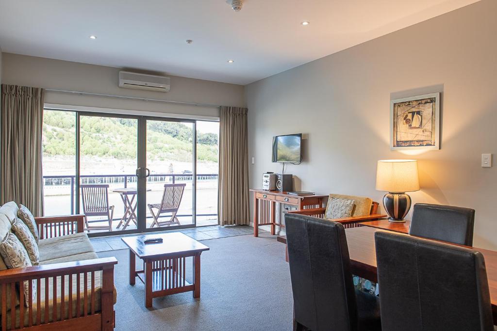 a living room with a table and a dining room at Portside Hotel Gisborne in Gisborne